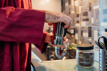 Middle section adult unrecongnizable man indoor home kitchen preparing coffee moka