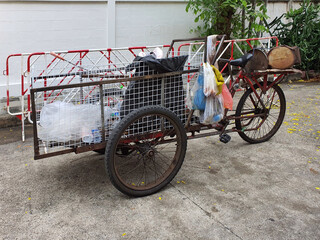 Fototapeta na wymiar Tricycle purchases paper, plastic bottles, metal, iron and old items that are no longer used. To be sold at a recycling plant in Thailand.