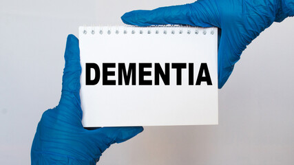 the doctor in gloves holds a card with the text DEMENTIA . white background. the medicine