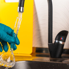 water purification specialist tap water pours into a glass flask.