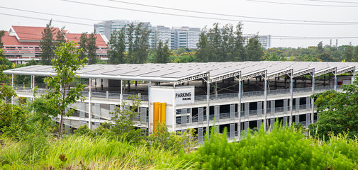 Fototapeta na wymiar Solar panels system lined up in a parking building to store solar electricity in Thailand. Many Solar cells in a row on top of roof, Natural day light, outside top view
