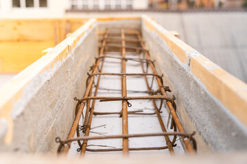 Obraz premium Reinforced belt in wooden formwork at a construction site close up