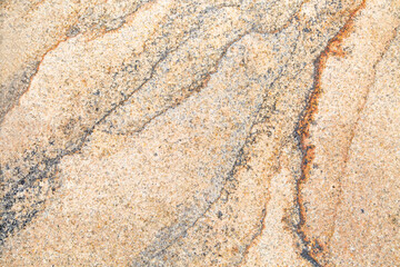 The background is made of light brown granite with lilac veins and a beautiful pattern similar to rivers or mountain slopes. Backgrounds design textures.