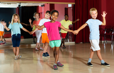 Fine children trying dancing partner dance in modern studio.