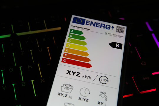 Viresen, Germany - May 8. 2021: Closeup of mobile phone screen with new european union energy label efficiency classes A - D, illuminated computer keyboard background