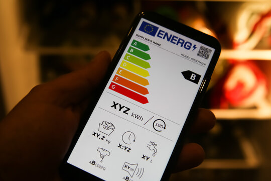 Viresen, Germany - May 8. 2021: Closeup of mobile phone screen with new european union energy label efficiency classes A - D, blurred fridge backgound