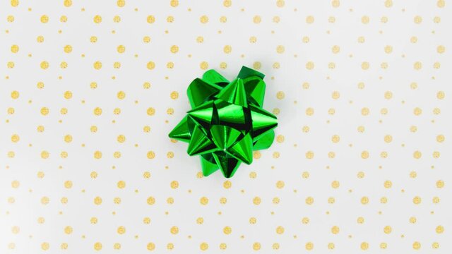 Unwrapping gift revealing a green screen - Stop Motion Animation - Green bow on a white background