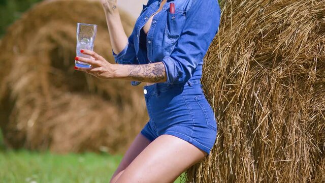 Attractive peasant woman resting in a field with hay and grass against the background of the forest.
Farmer girl leaning on a haystack. 
Perky girl fills a glass with ice for a Cocktail. Cola with ice