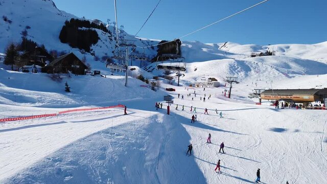 Skieurs descendant les pistes de la Toussuire vue du telesiege