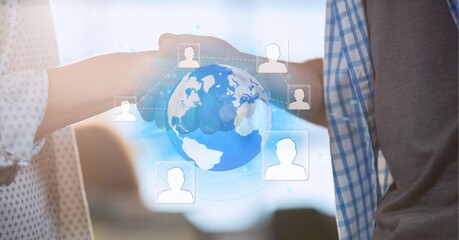 Network of profile icons over globe against mid section of two business people shaking hands