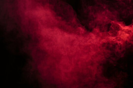 Smoke in red light on black background