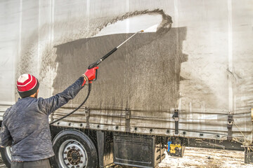 A dirty truck at a car wash.Washing with a water hose.