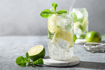 Freshness mojito with lime, mint, ice cube on gray background. Close up. Summer popular beverage.
