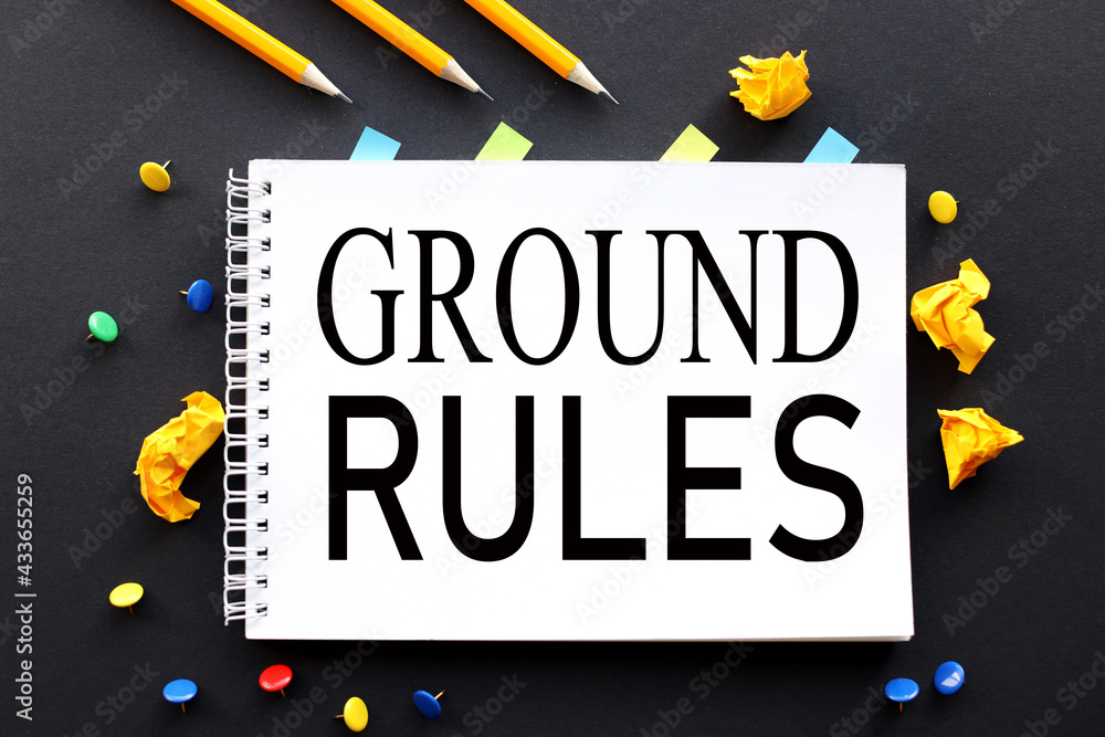 Poster ground rules. text on white paper on black background. and multi-colored buttons and crumpled paper