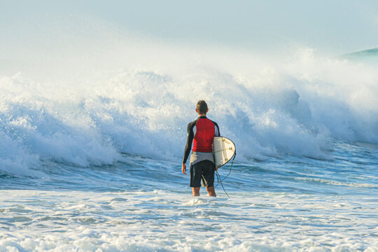 Surfer watches the waves and waits for a favorable opportunity to dive in