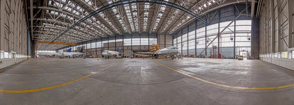 Image from an aircraft hangar with several passenger planes awaiting maintenance and repair