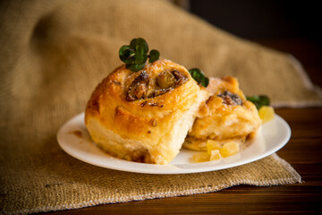 Sweet curled bun with jam, raisins in powdered sugar