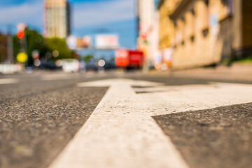 Summer in the city, the street on which cars travel. Close up view of a marking on the pavement level