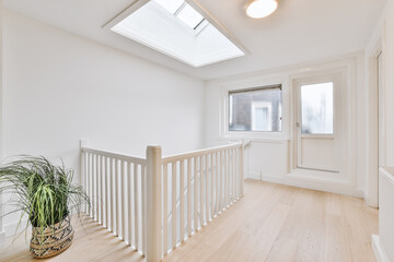 Element of stairway with white decorative balusters and wooden railings in vintage style apartment