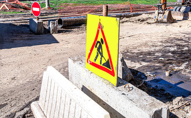 Under construction road sign on the closed road at the city street