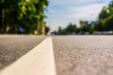 Summer in the city, the empty street. Close up view from the level of the dividing line