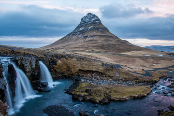 Long exposure at the Snæfellsnes Peninsula landmark view of Snæfellsjökull Volcano. Golden Circle views waterfall flowing dramatic landscape.