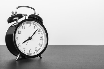 Classic alarm clock on black and white background. Time concept.