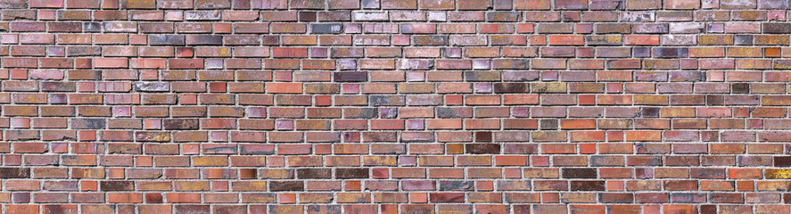 Bunte Grunge Backsteinmauer aus alten, beschädigten, meist metallicfarbenen Ziegelsteinen - Panorama Hintergrund
