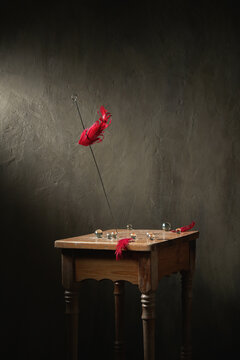 Decoration on metal stick on wooden retro stool with small crystal balls and feathers on gray background