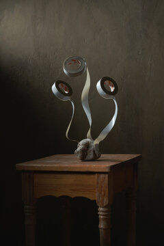 Stone with adhesive tape rolls representing flower bouquet concept on old wooden stool on gray background