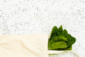 Salad Lettuce in white eco bag on white background zero waste concept