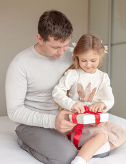 Father's day or Birthday concept. Father congratulating daughter and giving present at home.