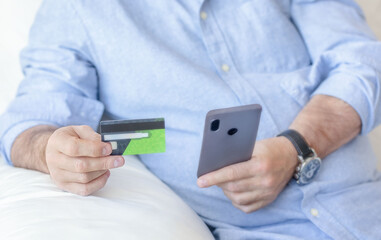 Man holding credit card and phone. Online shopping. Online banking concept.
