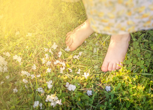 Little girl legs on the grass. Health and Relaxation concept.