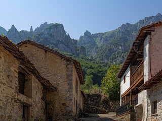 Vistas de las fachadas de unas casas rurales de piedra  con las monta&ntilde;as de fondo , en el pueblo de San Esteban de Cu&ntilde;aba en Asturias, Espa&ntilde;a, verano de 2020