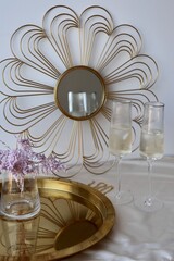 champagne glasses on a table and violet flowers in the mirror background