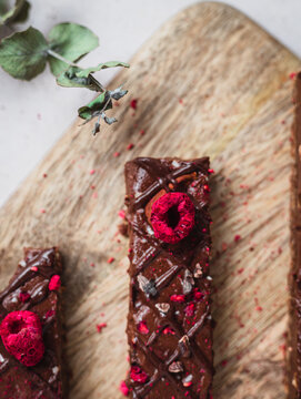 Close up of several chocolate bars with raspberry on a table