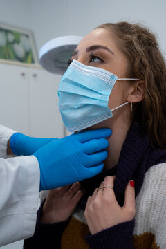 Unrecognizable medic in gloves examining lymph nodes of female patient during appointment in modern hospital