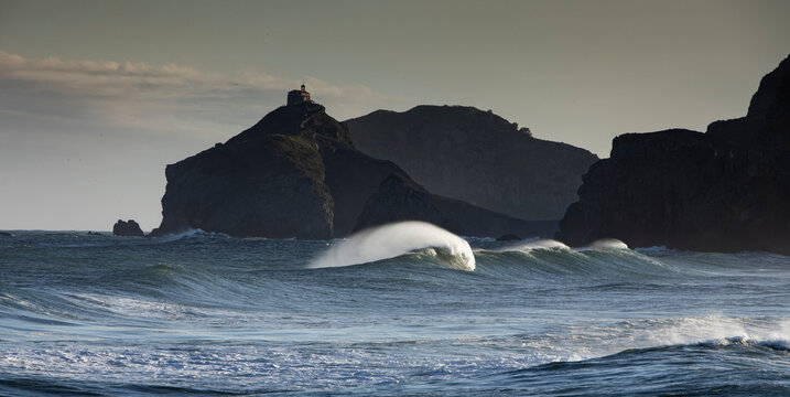 Picturesque view of Cantabrian Sea with fast waves against mounts in Bakio in province of Biscay Spain