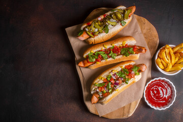Hot dogs with different mexican toppings, top view, dark background