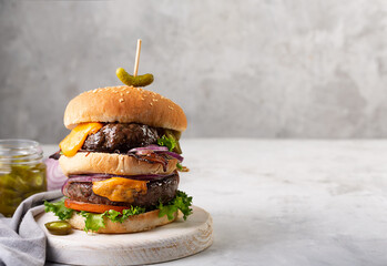 Home made burgers with two cutlets and jalapeno on a concrete gray background