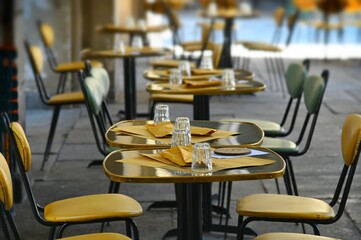 Empty restaurant terrace table yellow seats on sidewalk