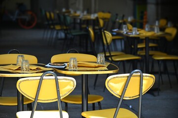 Empty restaurant terrace table yellow seats on sidewalk