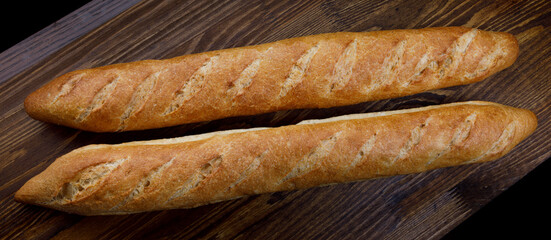 Two French baguettes on a cutting board.