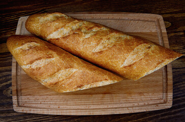 Two French baguettes on a cutting board.