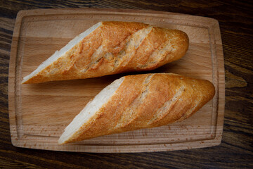 Sliced fresh crispy baguette on a wooden cutting board. art bread.