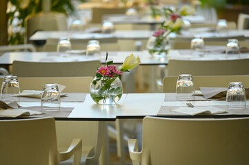 Rows of empty white restaurant terrace tables arranged for dinner