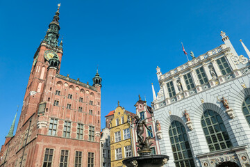 The Neptune's Fountain in Old Town of Gdansk, Poland. The fountain is located in the central point. Town Hall building in the back. City tour. Clear and bright day.