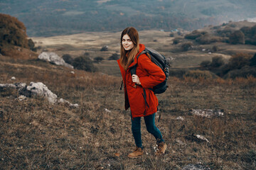 woman in a jacket with a backpack mountains steppe landscape autumn warm clothes model