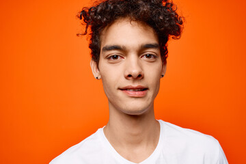 Obraz premium guy in white t-shirt curly hair cropped view studio